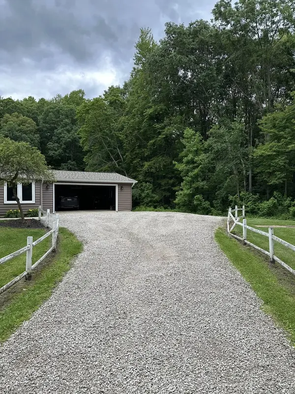 A driveway repaired with a fresh layer of gravel, graded by The Axe Man.